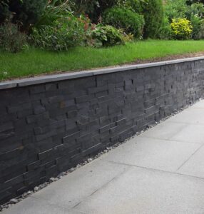 Blue black rock stack cladded wall with Rio slate copings &grey granite paving
